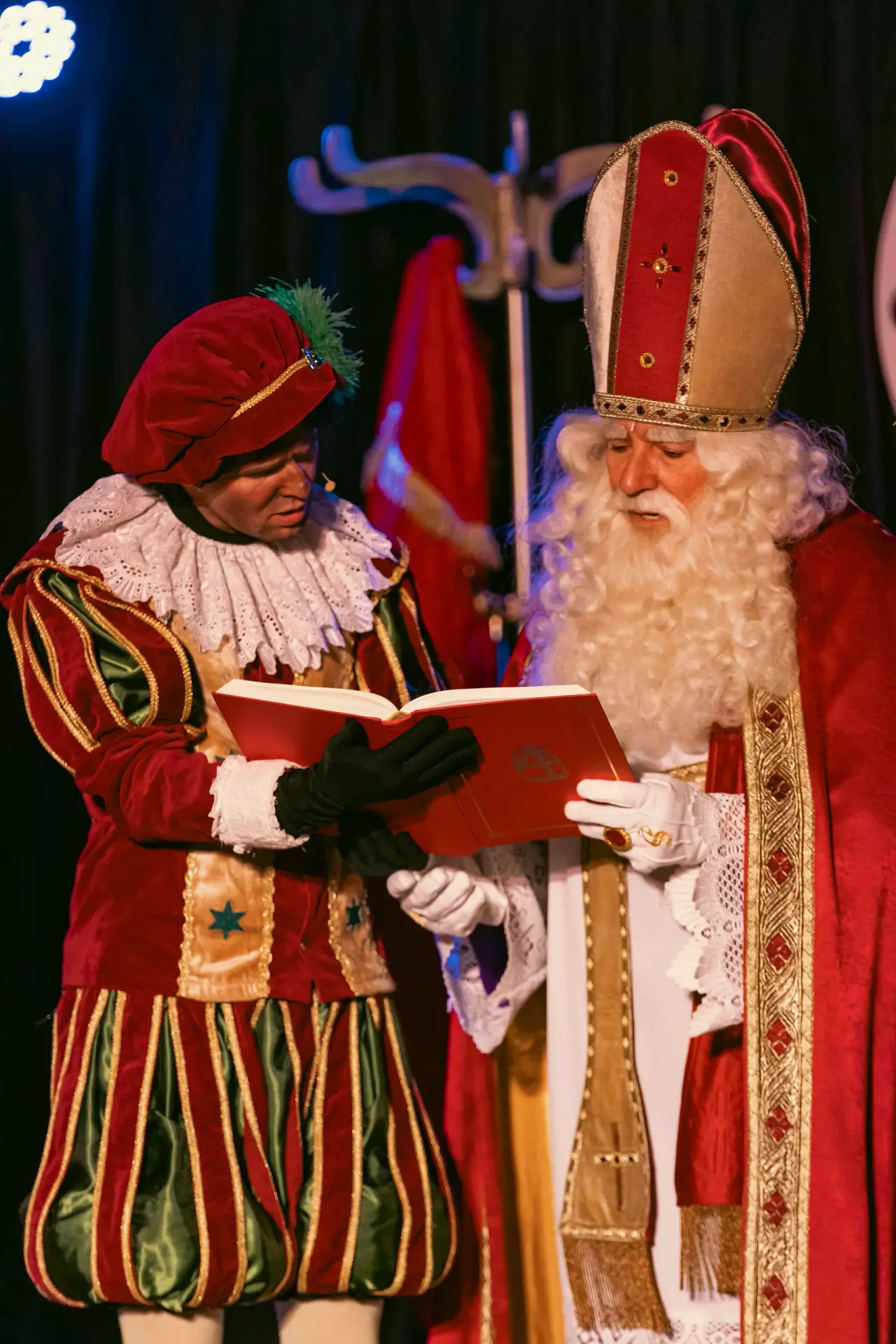 Sinterklaas en een piet lezen samen in het grote boek